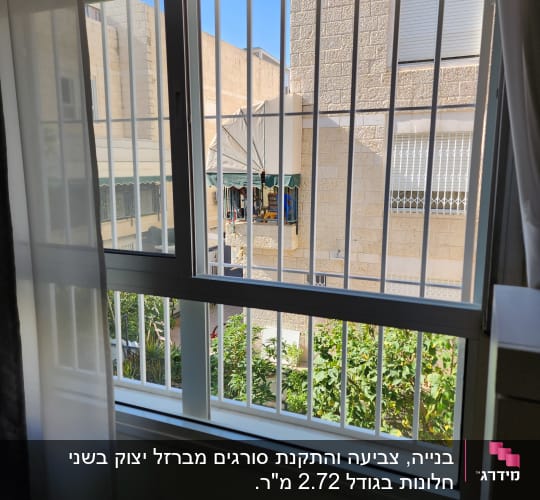 חלון עם סורגים לבנים, נוף חיצוני של בניין